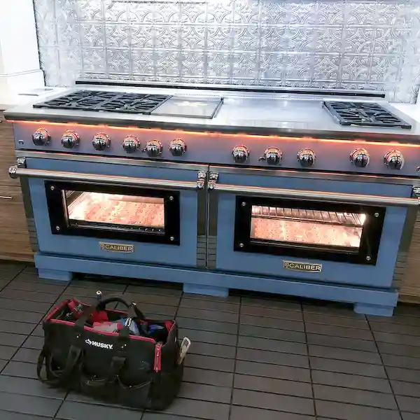 Caliber appliance repair technician servicing a luxury outdoor Caliber grill and outdoor kitchen appliance in Los Angeles